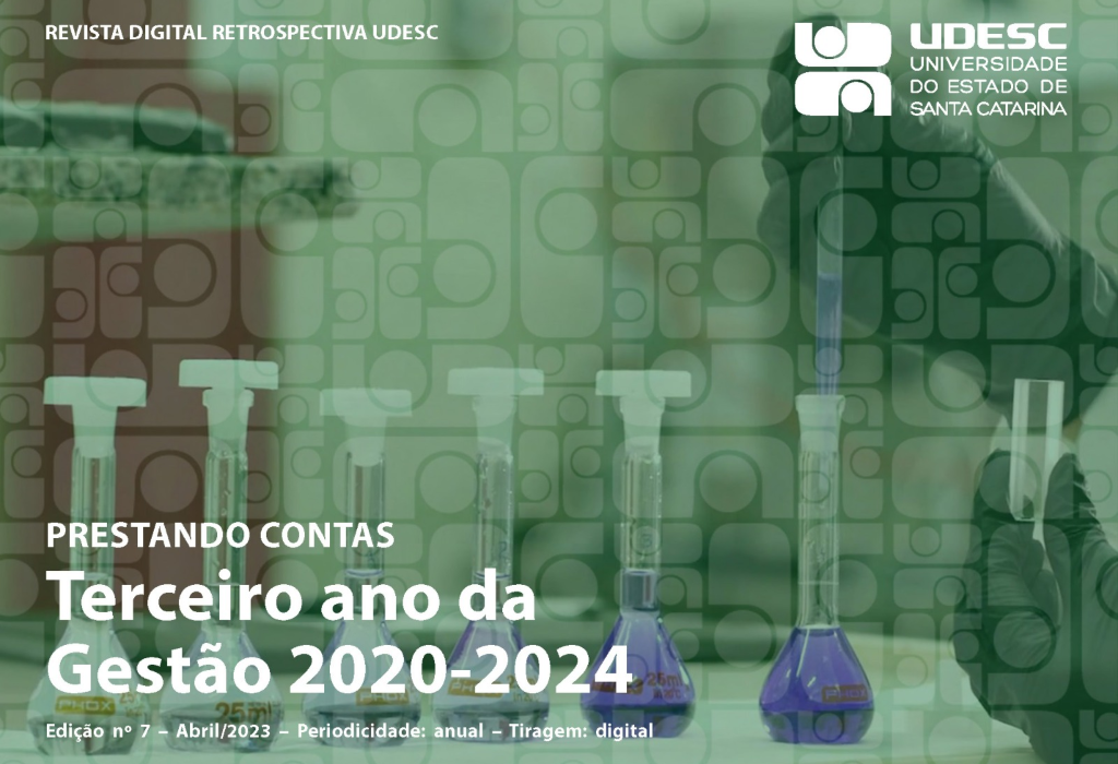 Capa da Revista Digital Retrospectiva Udesc. A capa tem a foto das mãos de um cientista, com luvas pretas, manuseando tubos de ensaio em um laboratório