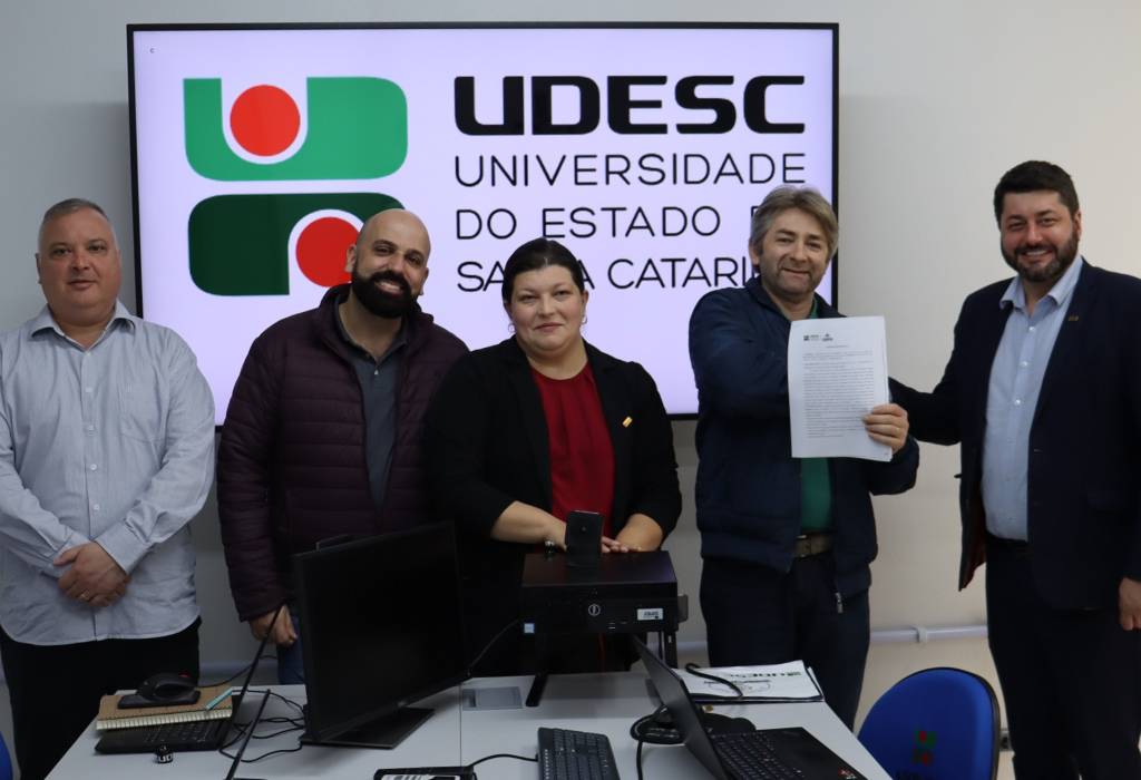Gestores da Udesc posam com documento da ordem de serviço assinada