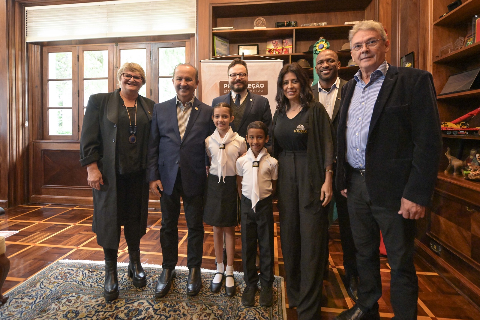 Foto do Governador de Santa Catarina, Jorginho Mello, junto com o Presidente da Fundação de Cultura Catarinense, Rafael Nogueira, e o presidente da Celesc, Tarcísio Rosa. Também estão posando representantes da Escola Bolshoi e dois alunos.