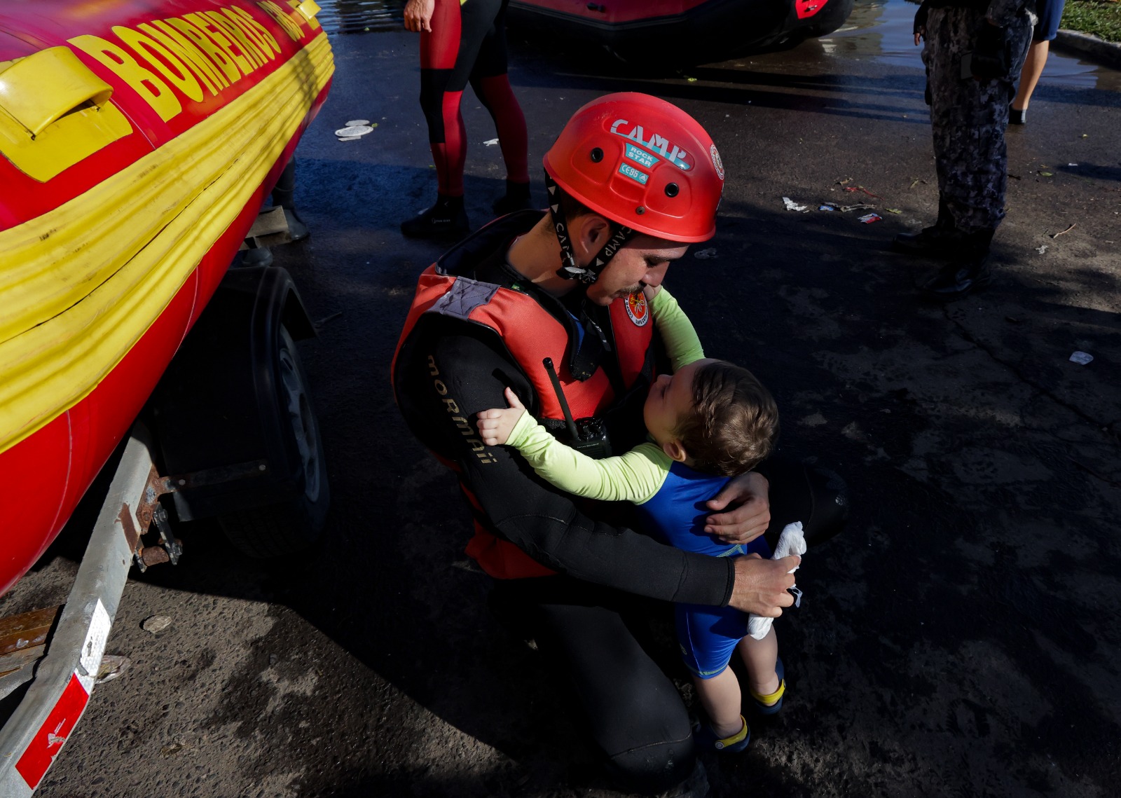 Bombeiro abraça criança em operação de resgate no RS